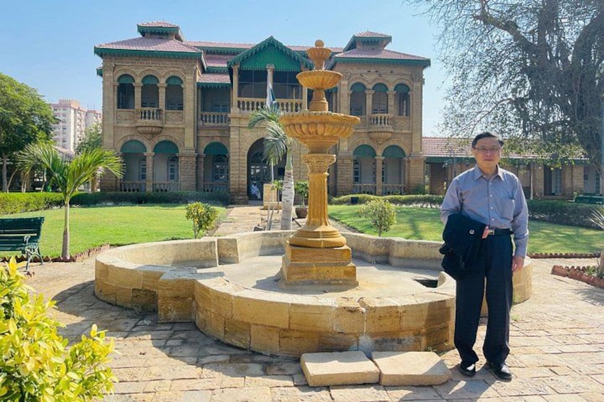 A man standing in front of a fountain with a building in the background. 2
