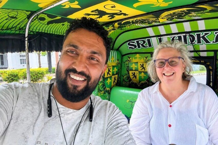 Zwei Personen in einem grün-gelben Fahrzeug, auf dem 'Sri Lanka' steht. 1