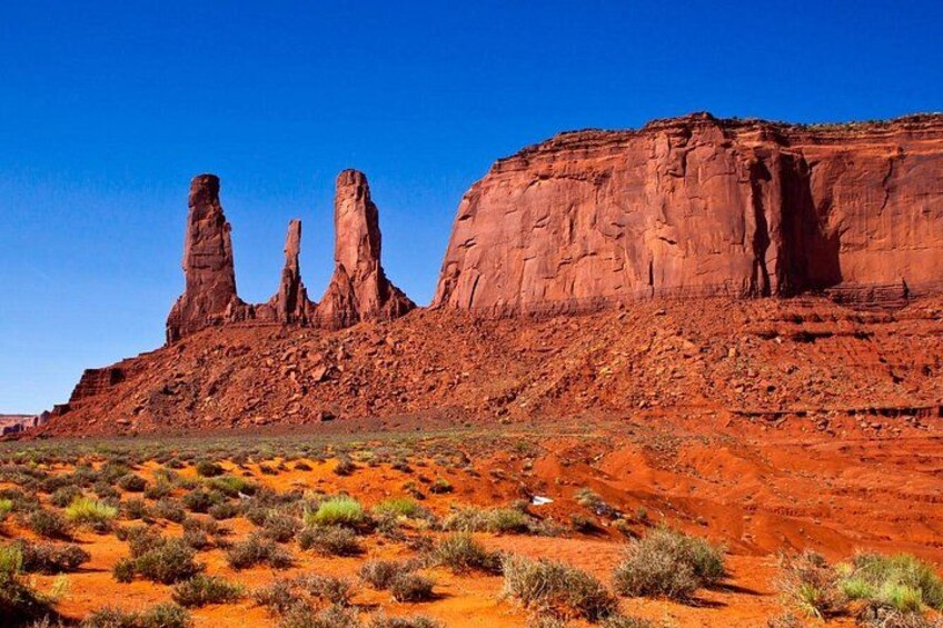A desert landscape with red rock formations and sparse vegetation. 3