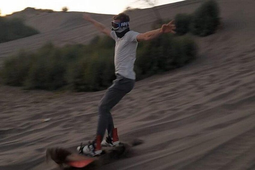 A person riding a red dirt bike on a dirt track. 2