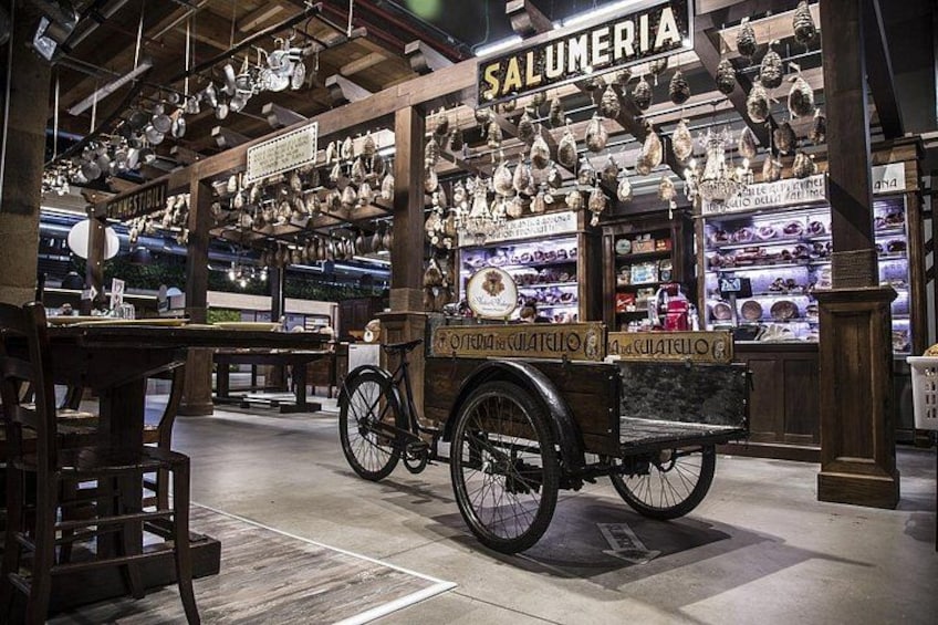 A vintage bicycle cart in a market with various pottery items on display. 3