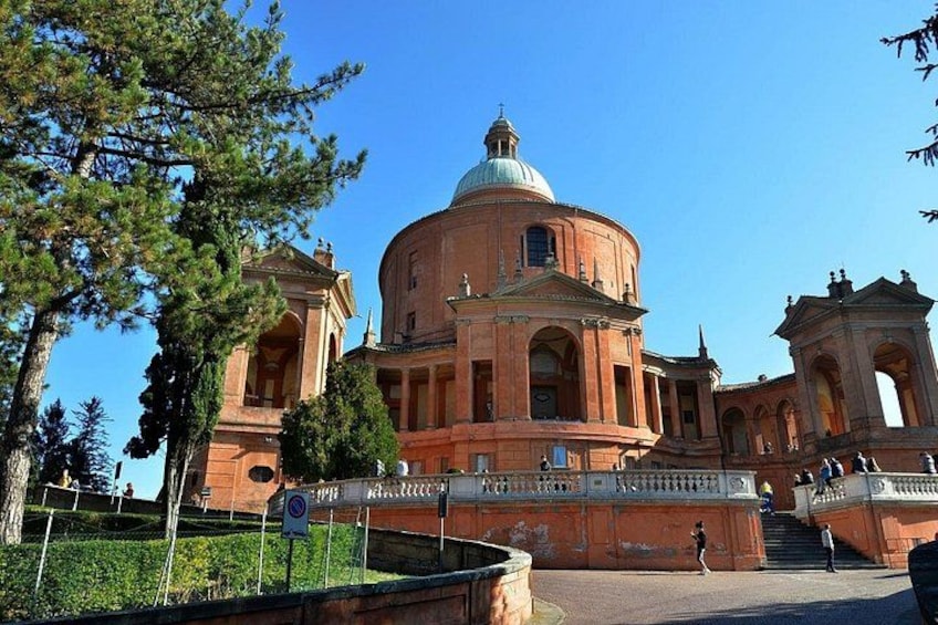 A large domed building with arched windows and a central dome, surrounded by trees and a paved walkway. 2