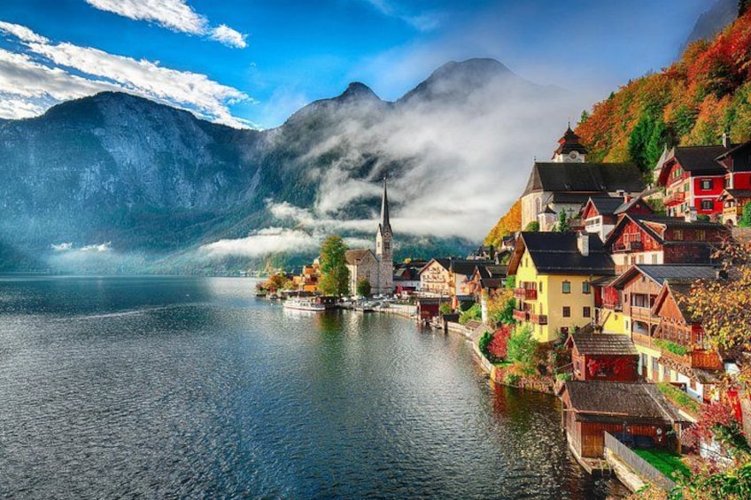 Ein Seeuferdorf mit bunten Häusern, einer Kirche und Bergen im Hintergrund. 2
