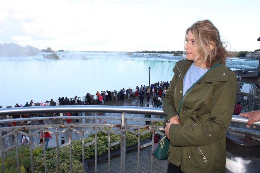 A person standing by a railing overlooking a waterfall. 3