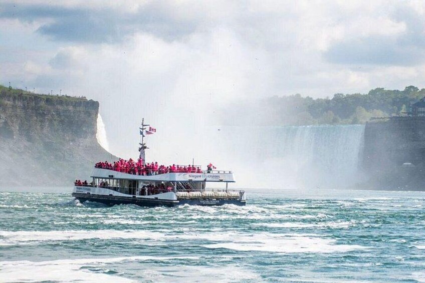 A boat with passengers near a waterfall. 2