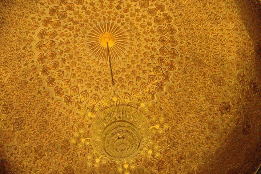 A detailed, ornate ceiling with a central circular design and radiating patterns. 2