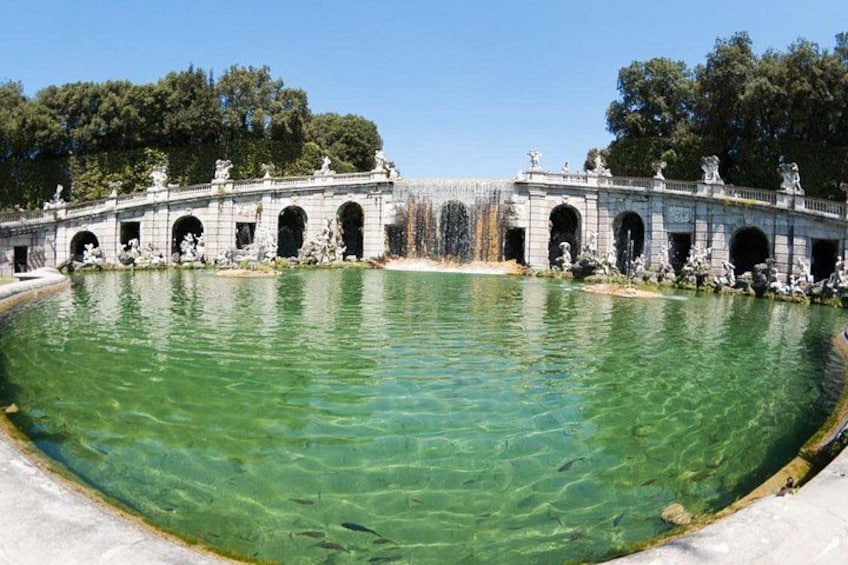 A clear pool with a stone bridge and statues. 2