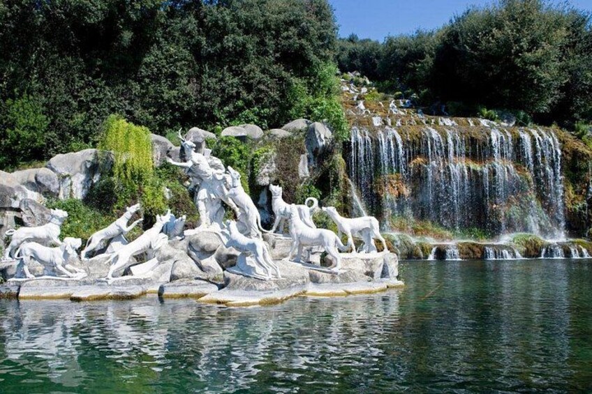 A sculpture of horses and riders by a waterfall. 3