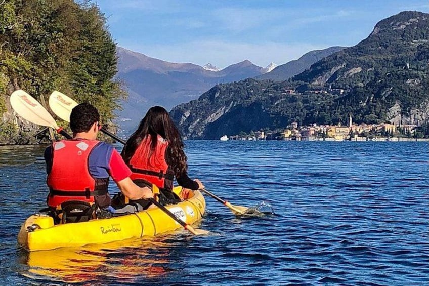 Dos personas en kayak en un lago, con montañas al fondo. 1
