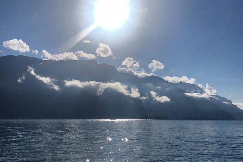 Una cordillera de montañas, una masa de agua y un cielo despejado con luz solar. 4