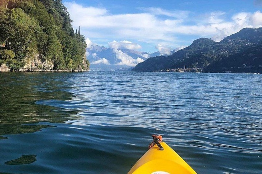 Un kayak sobre aguas tranquilas con montañas y un área boscosa al fondo. 2