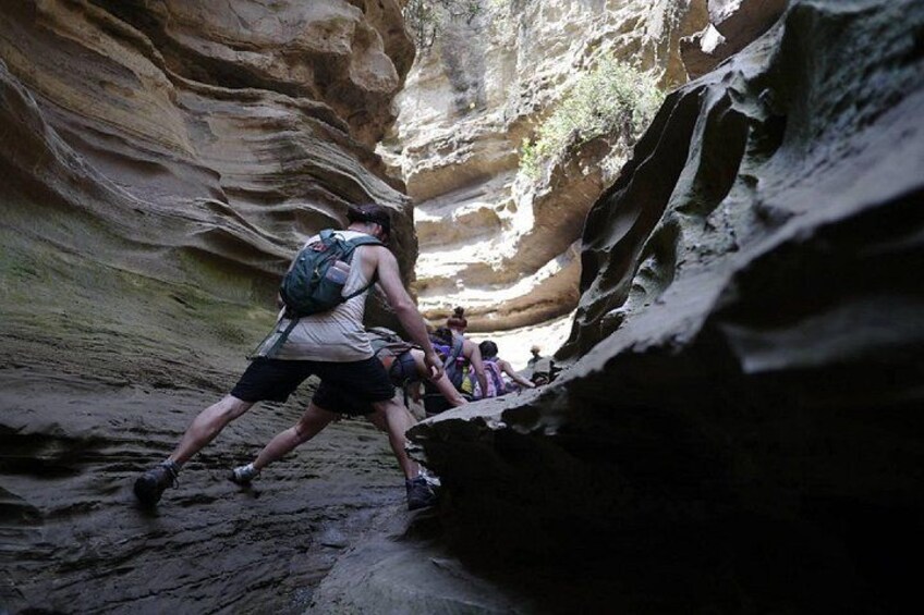 Un groupe de randonneurs traverse un étroit canyon aux parois rocheuses abruptes. 4