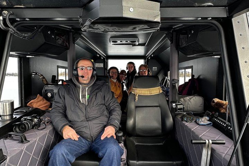 L'intérieur d'un véhicule, avec une personne assise sur le siège du conducteur, un volant et un tableau de bord doté de divers éléments de commande. 2