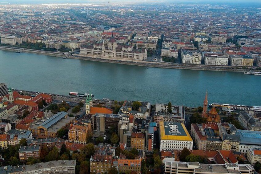 En stadsbild med en flod, historiska byggnader och en framträdande kyrka. 5