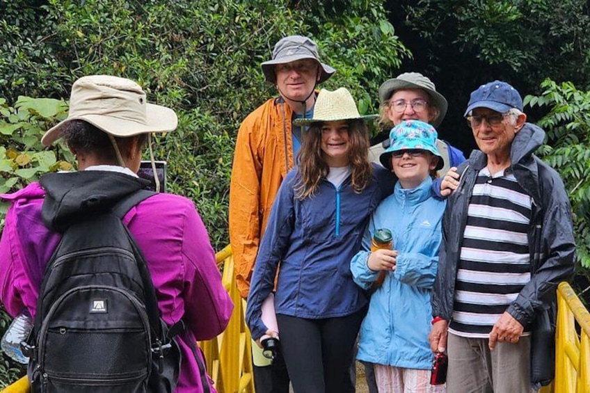 A group of people on a yellow bridge surrounded by greenery. 1