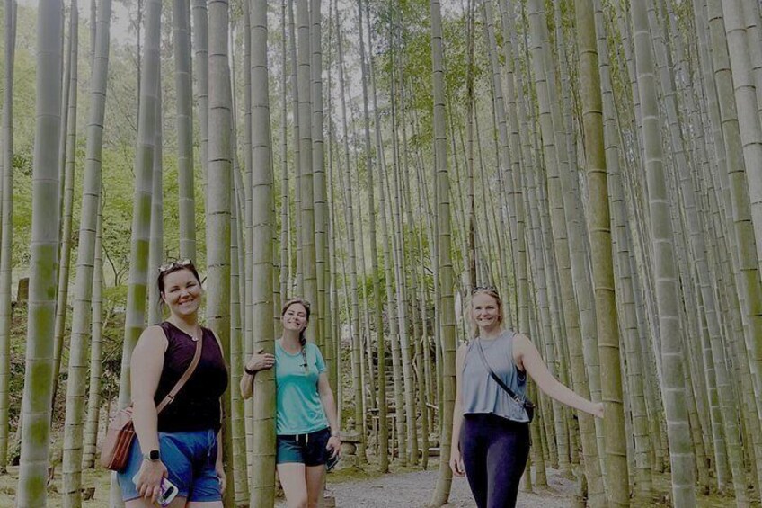 Three people standing in a bamboo forest. 5