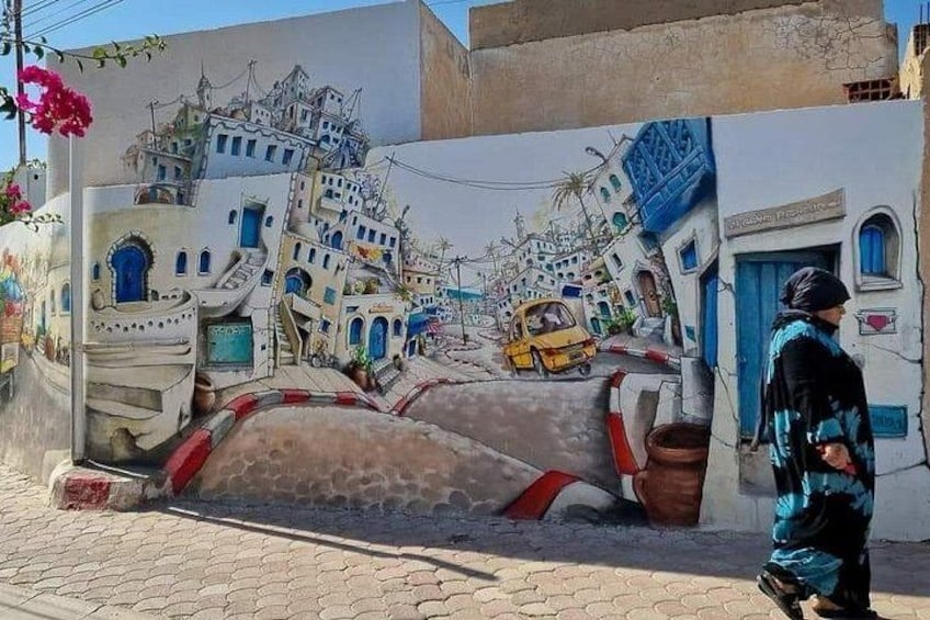 Une fresque murale représentant un immeuble blanc avec des portes et des fenêtres bleues, un taxi jaune et une personne qui marche. 1