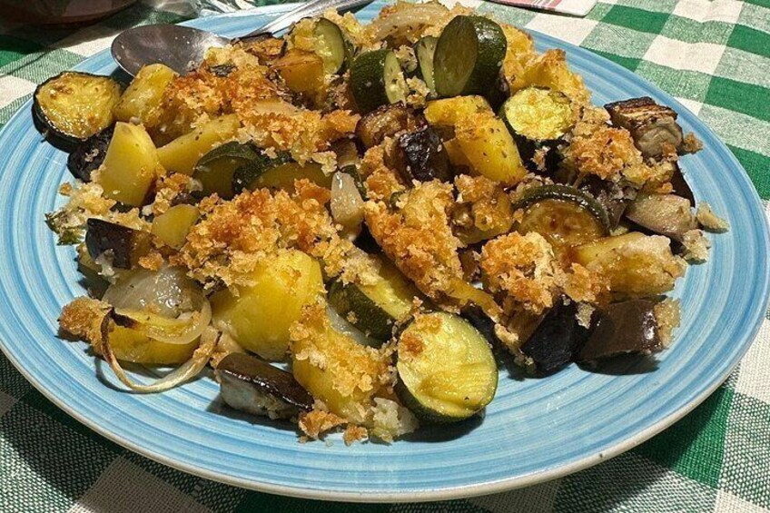 A plate of roasted vegetables with a crumbly topping, served on a blue plate. 5