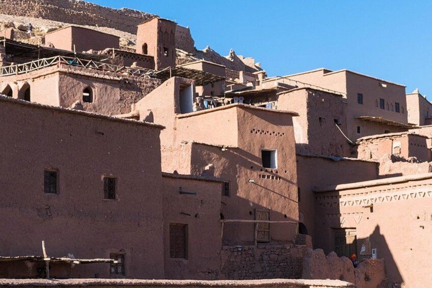 A traditional mud-brick village with tiered buildings and a clear blue sky. 5