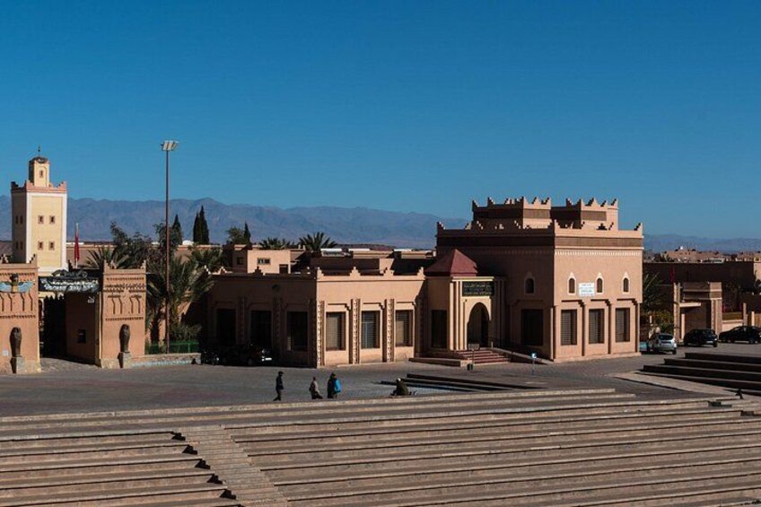 A historic building complex with a prominent tower and arched gateways. 4