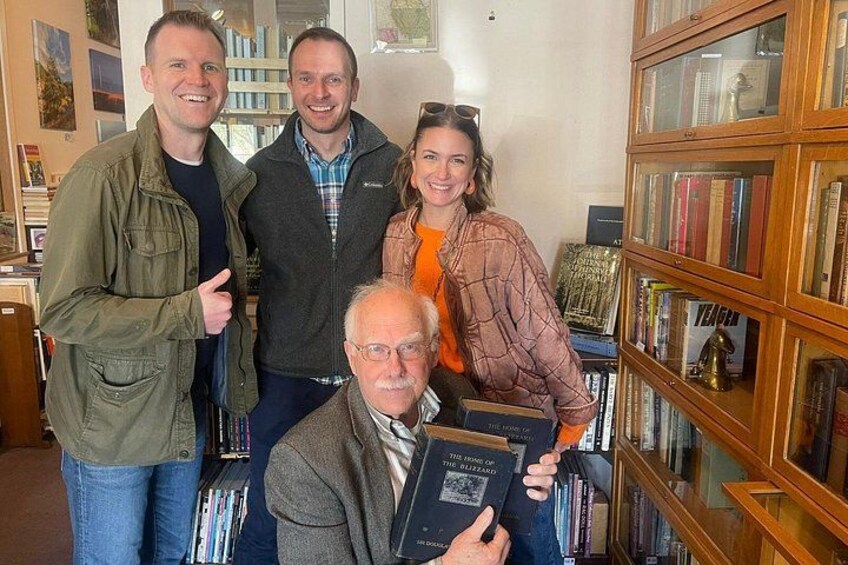 A group of people in a room with bookshelves. 5