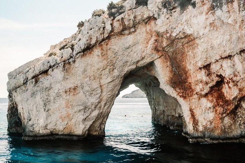 A large rock arch over water. 1