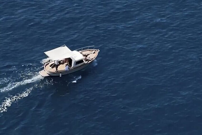 A small boat with a canopy sailing on the water. 3