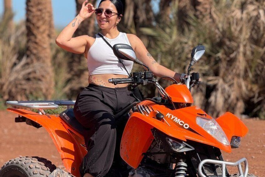 Een persoon rijdt op een Kymco ATV door een woestijnlandschap met schaarse begroeiing. 4