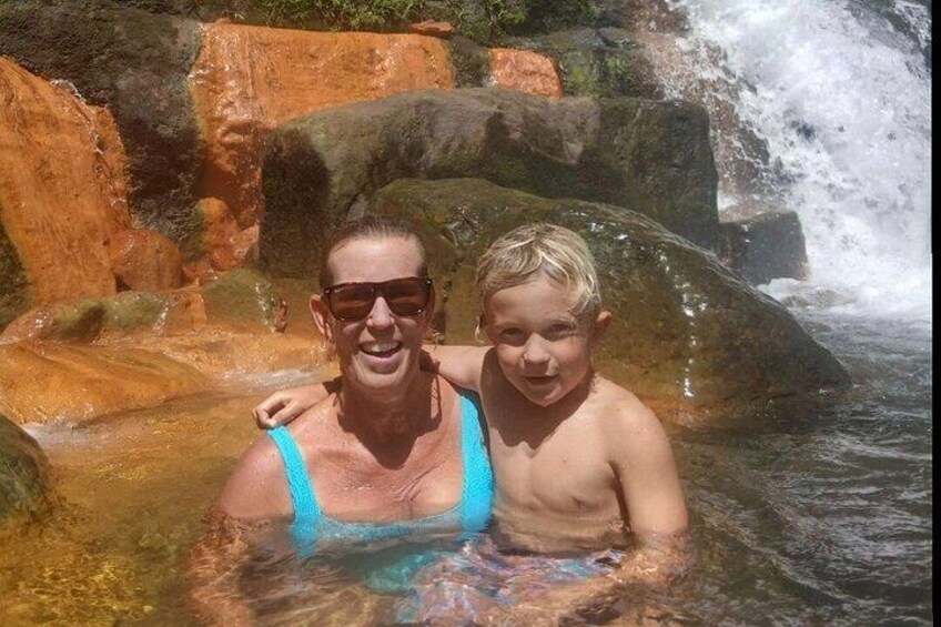 Zwei Personen in einer natürlichen Wasserlandschaft mit Felsen und einem Wasserfall. 4