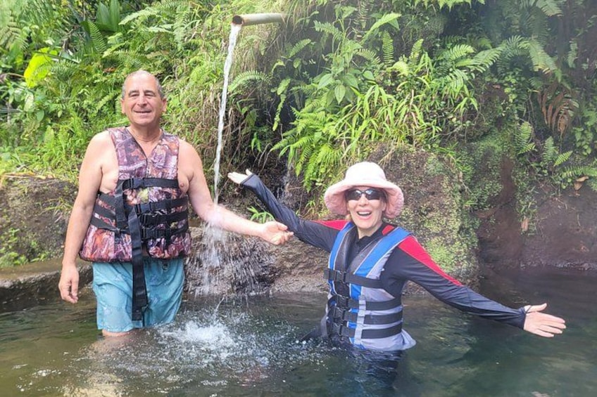 Two people in a water body, one wearing a life jacket and the other holding a hose. 5