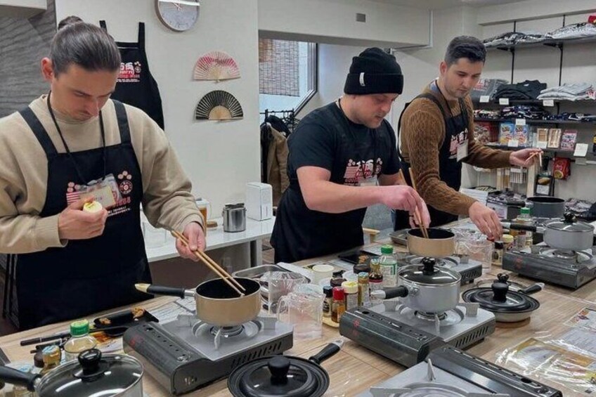 Des chefs cuisinent dans une cuisine équipée de casseroles, de poêles et d’ustensiles de cuisine. 2
