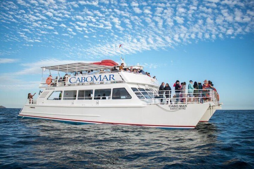 Un barco blanco llamado CABOMAR con pasajeros en la cubierta, navegando en el océano. 2