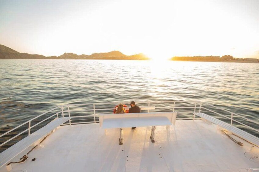 A boat with a bench in the middle, calm water, and a sunset in the background. 3