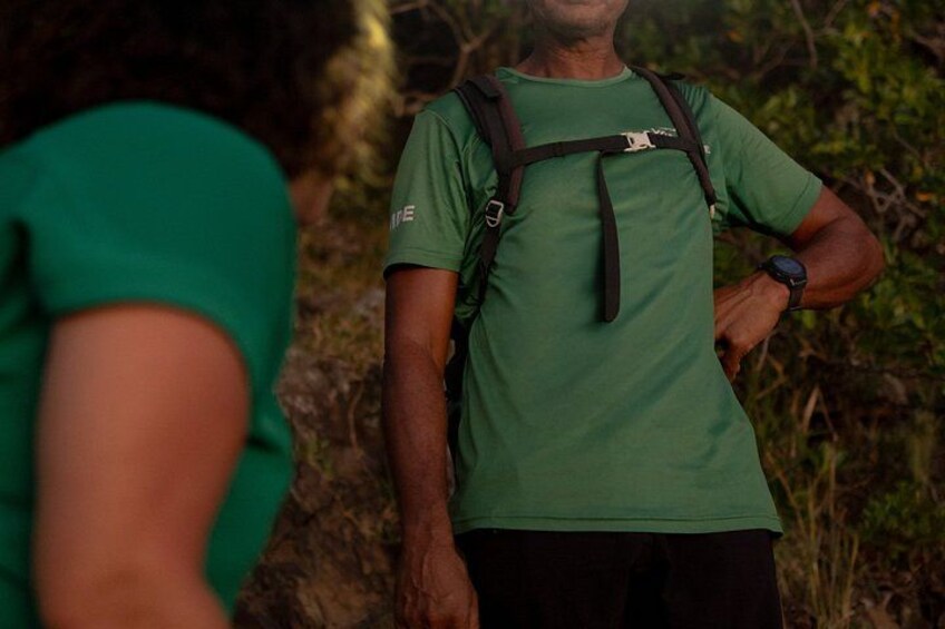 Eine Person mit grünem Hemd und Rucksack steht draußen. 5