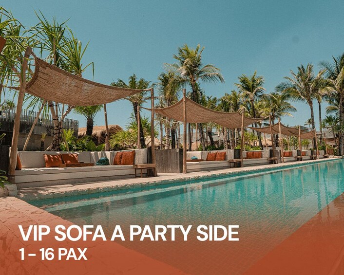 A poolside area with VIP sofas and thatched umbrellas. 3