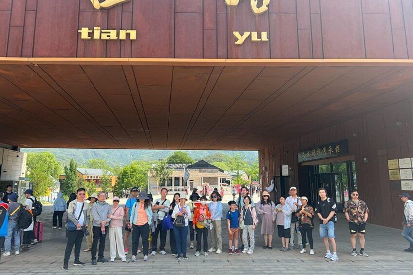 A group of people standing in front of a building with the sign 'tian yu'. 3