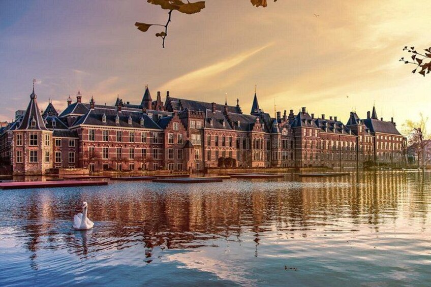A historic building with a reflective water surface and a swan. 1