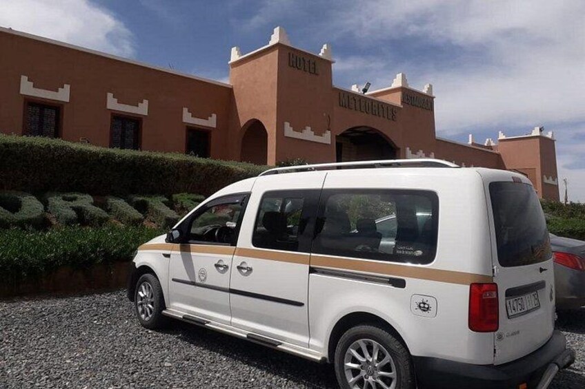 A white van parked in front of a building with a sign that reads 'HOTEL'. 4