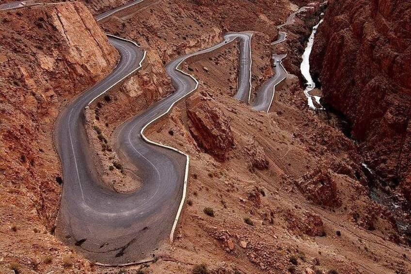 A winding mountain road with sharp bends and a narrow shoulder. 5