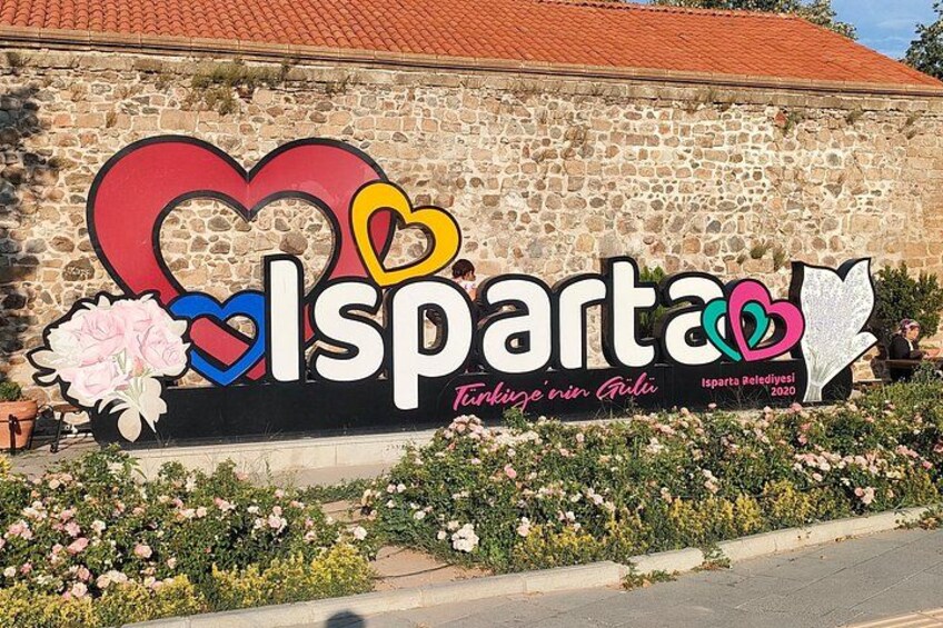 Una pared de piedra con un cartel colorido que dice 'Isparta' y 'Turkiye'nin Gibi'. 1