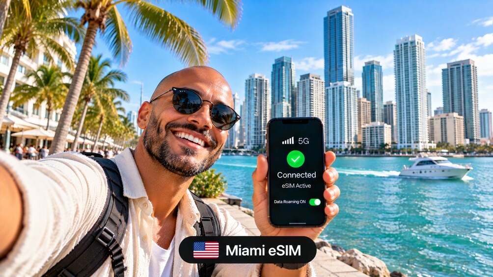 A person holding a smartphone displaying a 5G connection with eSIM active, palm trees, a body of water, and a city skyline in the background. 2