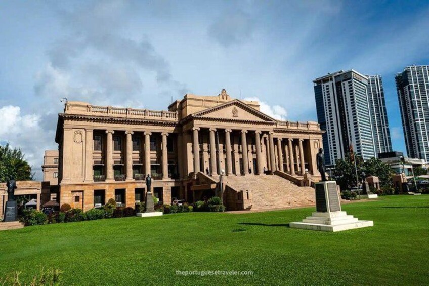Un grand bâtiment de style classique, doté de colonnes, d’une statue et d’une pelouse bien entretenue. 2