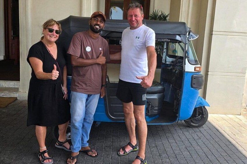 Tre persone in piedi davanti a un veicolo blu e nero con lo sportello aperto. 1