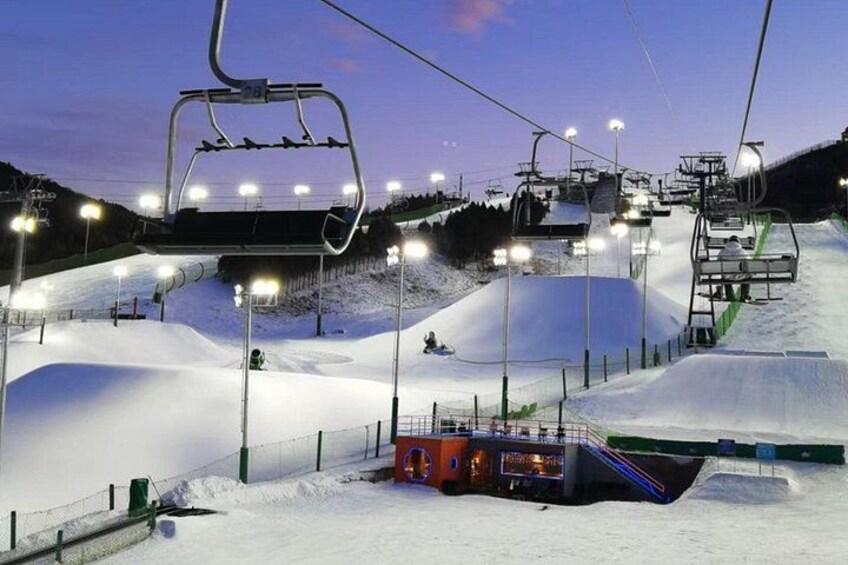 A snow-covered ski slope with ski lifts and a chairlift. 4