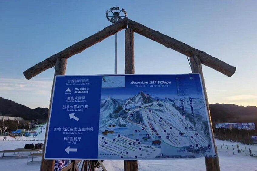 A signboard with directions to the Nanshan Ski Village and a ski slope. 3