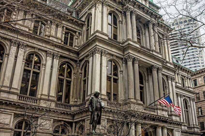 A historic building with ornate architecture, including columns and arched windows, and an American flag. 2