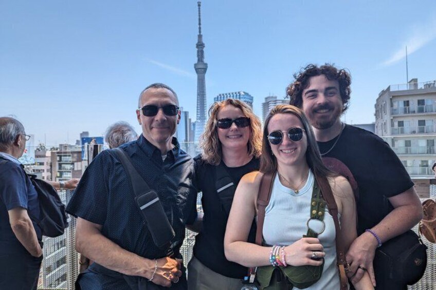 Un gruppo di persone in piedi su un tetto con lo skyline di una città sullo sfondo. 3
