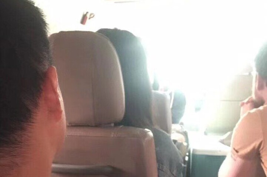 A person sitting in a vehicle with a beige interior. 2