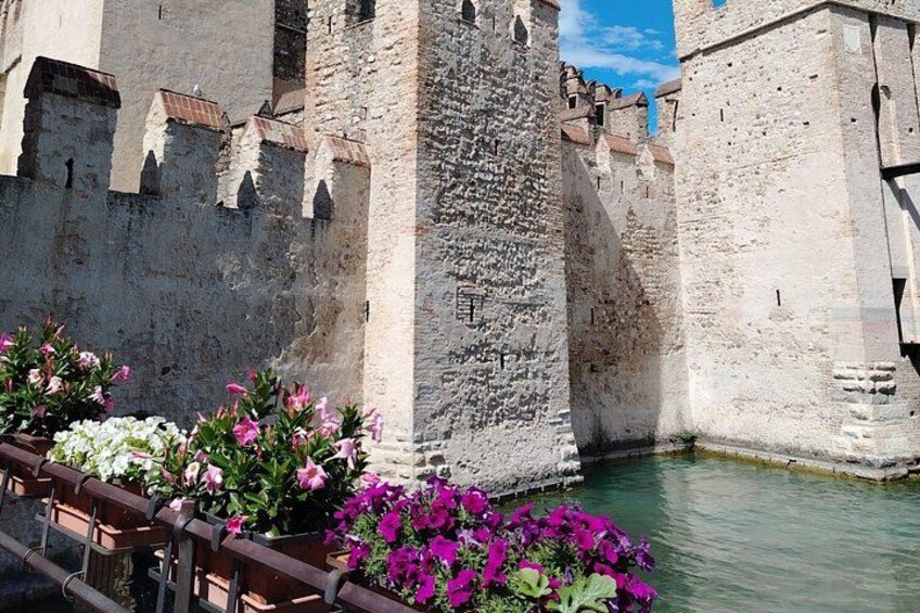Un mur de pierre ancien, bordé d’un fossé et entouré de fleurs aux couleurs vives. 4