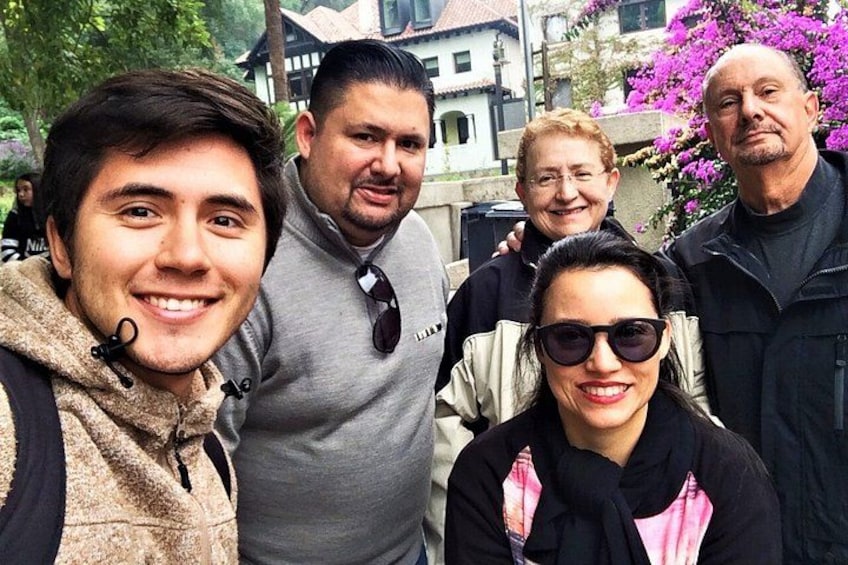 Un grupo de personas al aire libre, con edificios y árboles al fondo. 5